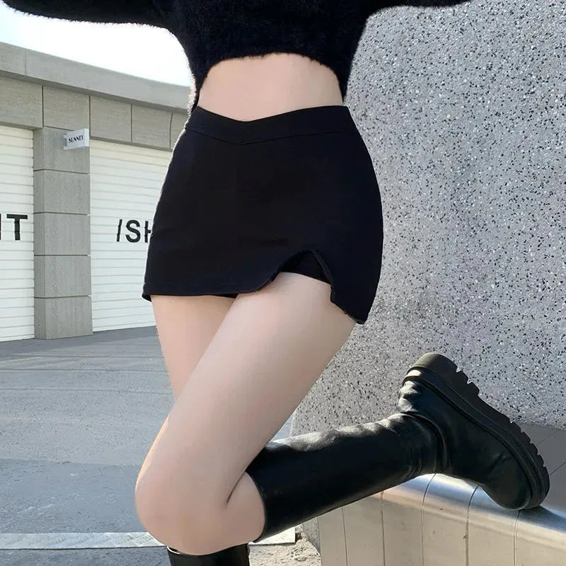 Black asymmetric split mini skirt styled with knee-high boots outdoors