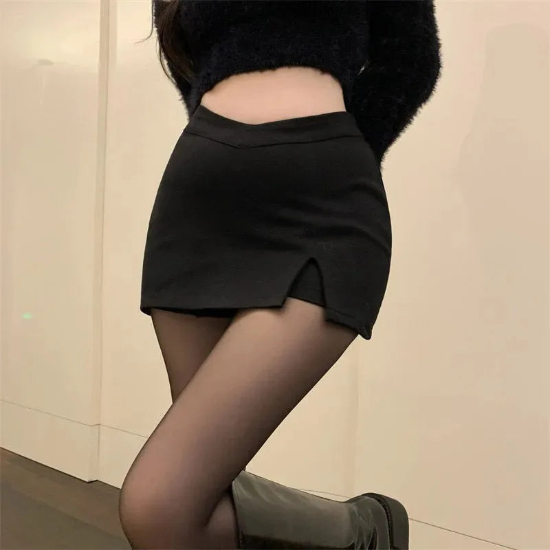 Black asymmetric split mini skirt styled with a black jumper and tights