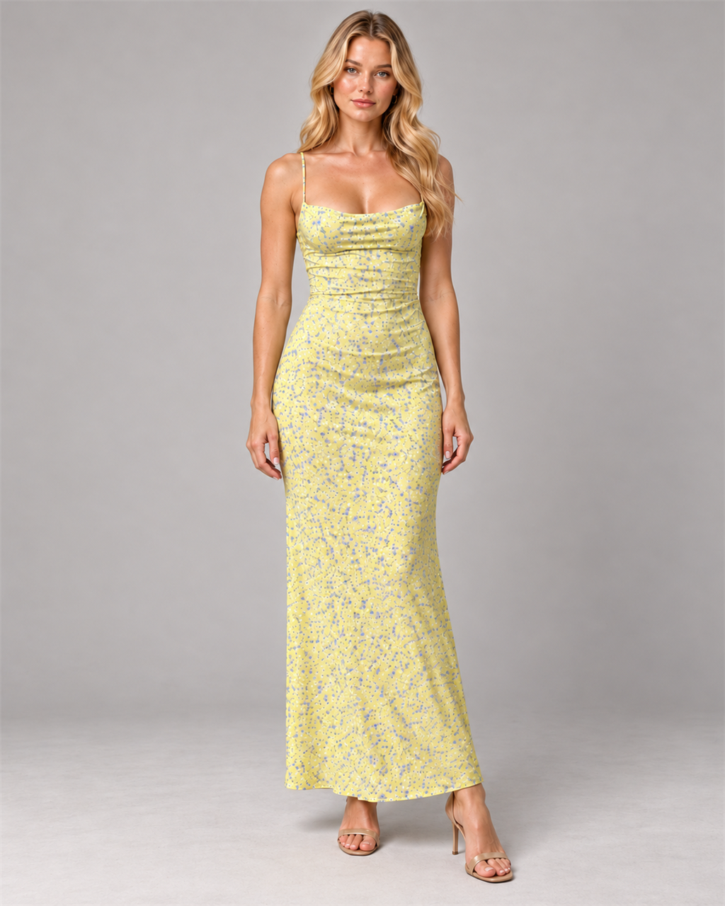 Blonde model wearing the yellow Floral Open-Back Maxi Dress with beige heels, calm neutral expression