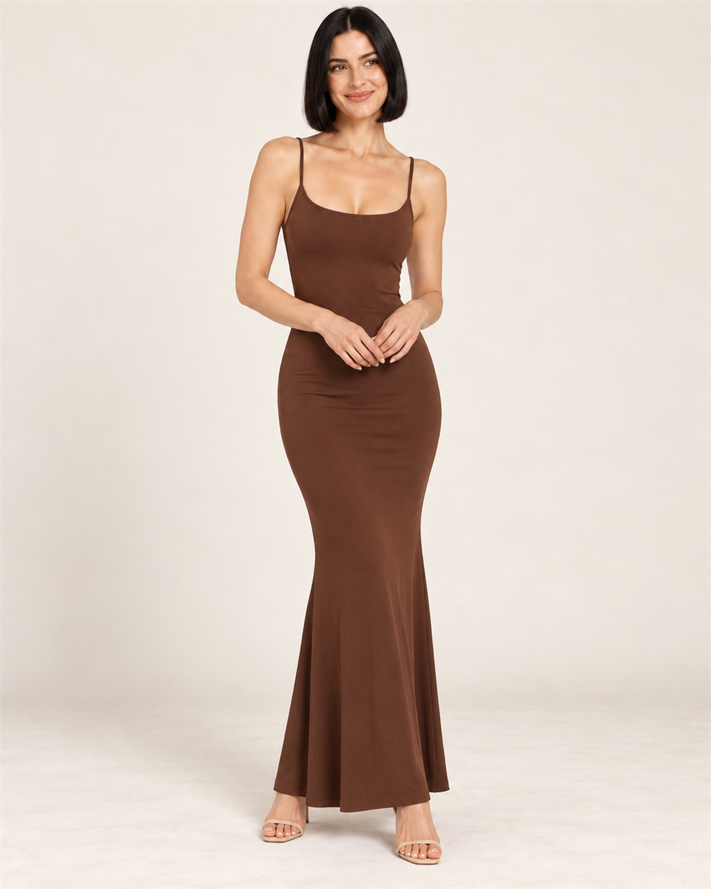 Model with a black bob wearing the brown Open-Back Bodycon Maxi Dress, soft closed-lip smile and champagne sandals